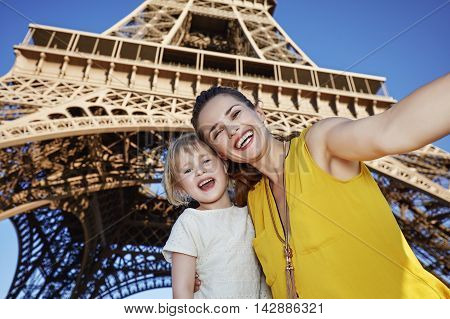 Happy Mother And Child Taking Selfie In Front Of Eiffel Tower