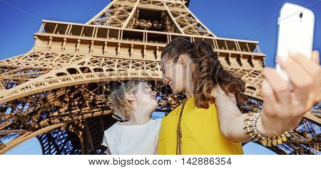 Mother And Daughter Tourists Taking Selfie Against Eiffel Tower