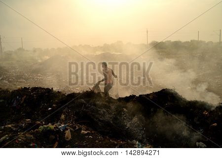 AMRAVATI, MAHARASHTRA, INDIA - APRIL 09, 2014: Unidentified people looking for something in the garbage at Big garbage land. Land and air pollution in India on April 09, 2014, Amravati, India.