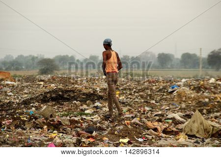 AMRAVATI, MAHARASHTRA, INDIA - APRIL 09, 2014: Unidentified people looking for something in the garbage at Big garbage land. Land and air pollution in India on April 09, 2014, Amravati, India.