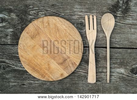 Cutting board on rustic wooden background. Top view
