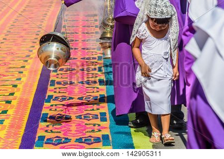 Antigua Guatemala - March 25 2016: Locals reenact biblical scenes walking over handmade dyed sawdust carpets & burning incense on Good Friday in colonial town with most famous Holy Week celebrations in Latin America.
