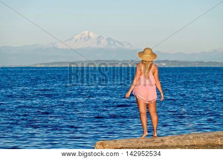 Young woman on beach looking at ocean. Centennial Beach in Boundary Bay Regional Park Tsawwassen British Columbia Canada