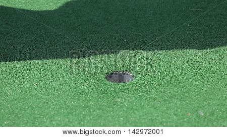 Golf Ball Sinking into the green Hole