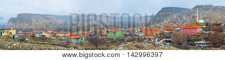 Panorama of Selime town with the colored cottages high white minaret and giant rocky mountain ranges Cappadocia Turkey.