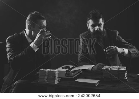 Illegal Business Concept. Company Engaged In Illegal Business. Men Sitting At Table With Piles Of Mo