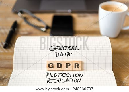 Closeup On Notebook Over Wood Table Background, Focus On Wooden Blocks With Letters Making Gdpr Gene