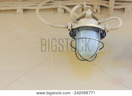Old Vintage Lamp On Ship Deck Wall Surrounded By Metal Rustic. Bulkhead Light On Navy Ship Against R