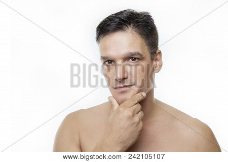 Shirtless Young Man With Hand To Chin Against White Background. Studio Shot