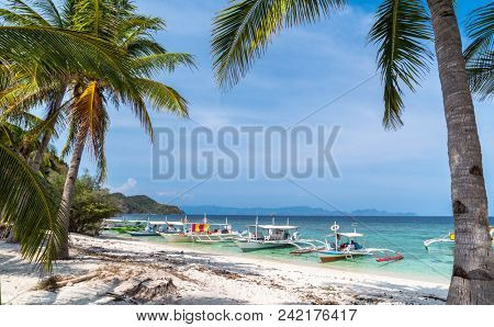Tropical beach with boats on the Malcapuya Island, Busuanga, Palawan, Philippines. Beautiful tropical island with sand beach. Travel concept