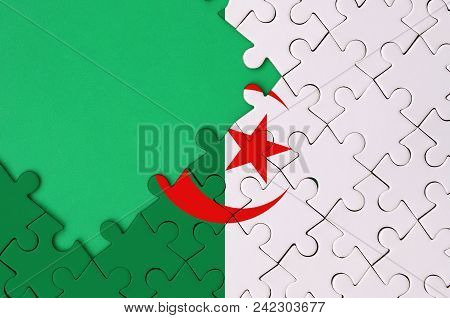 Algeria Flag  Is Depicted On A Completed Jigsaw Puzzle With Free Green Copy Space On The Left Side.