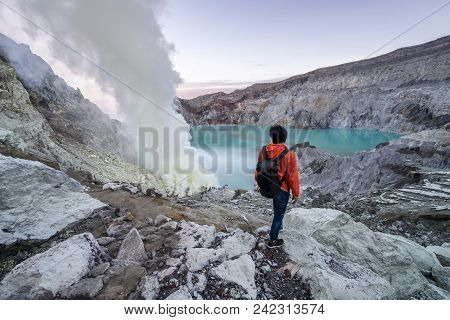 Young Travler Looking At Sulfur Burned By Blue Flame In The Crater Blue Lake At Kawah Ijen, Indonesi