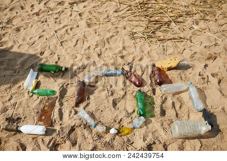 Word sos made up of old plastic bottles and other litter on sandy beach