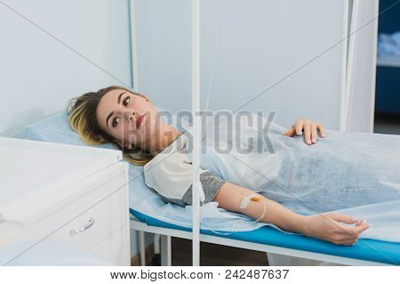 Pensive Woman Transfused Lying In Hospital Ward.
