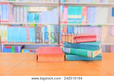Old Book Red - Green. And Heap Treatise In School Library On Wooden Table.  Blurry Bookshelves Backg
