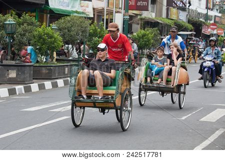 YOGYAKARTA - AUGUST 03: Traditional rikshaw transport on streets of Yogyakarta, Java, Indonesia on August 03, 2010. Bicycle rikshaw remains popular means of transport in many Indonesian cities.