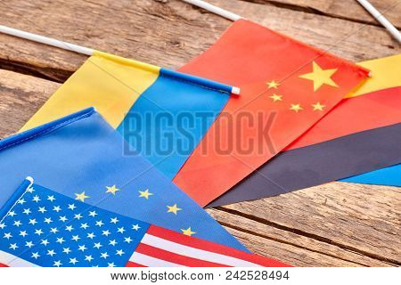 Close Up Flags Collection On Wooden Table. Flat Lay, Top View. Wooden Desk Background.