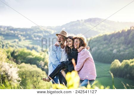 Cheerful Senior Couple With Grandaughter Outside In Spring Nature, Relaxing And Having Fun.