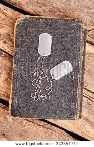 Old Book And Dog Tags. Top View, Flat Lay. Wooden Desk Background.