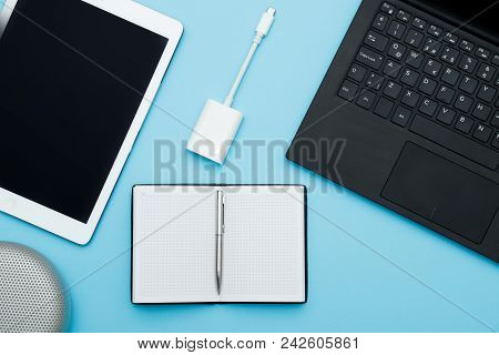 Overhead Of Office Table With Laptop, Computer Keyboard, Tablet Pc And Notebook, Speaker, Ports Adap