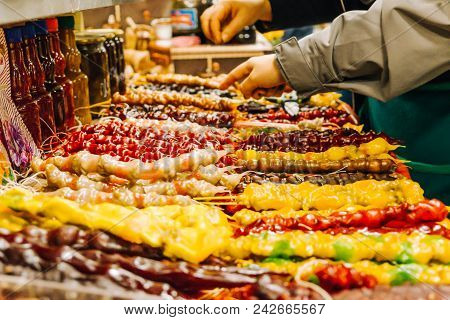 Girl Chooses Churchkhel On A Market, Oriental Dessert From Grapes And Nuts