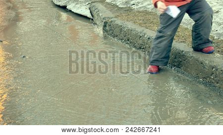 Girl In Rubber Boots Jumping On Puddle Near Wite Paper Boat 4k