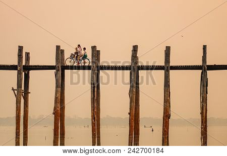 Mandalay, Myanmar - Feb 22, 2016. People On U Bein Bridge At Sunrise In Mandalay, Myanmar.