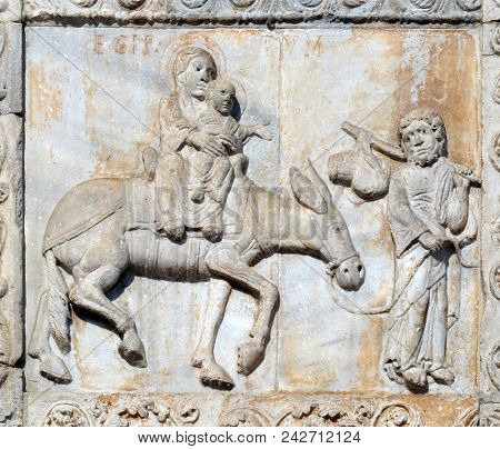 VERONA, ITALY - MAY 27: Flight in to Egypt, medieval relief on the facade of Basilica of San Zeno in Verona, Italy, on May 27, 2017.