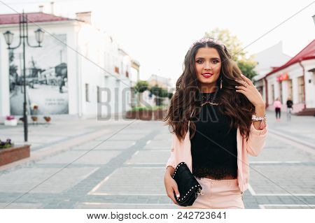 Portrait Of Beautiful Smiling Woman With Long Brunette Hair And Make Up Wearing Pink Sport Chic Suit