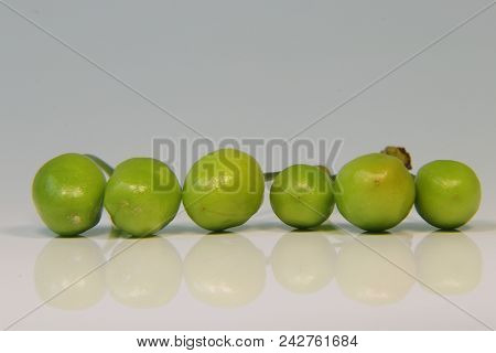 A Six Immature Cherry Balls On White Background With Mirroring Effect