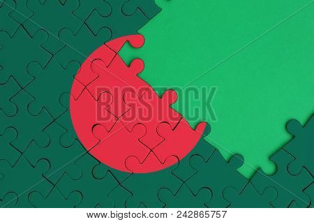 Bangladesh Flag  Is Depicted On A Completed Jigsaw Puzzle With Free Green Copy Space On The Right Si