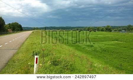 Typical Dutch River Landscape With A Dike, Floodmeadow And A River. Image Made With A Smartphone.