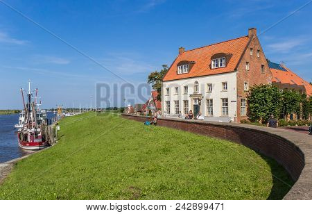 Greetsiel, Germany - July 18, 2017: Dike And Old House In Teh Historic Harbor Of Greetsiel, Germany