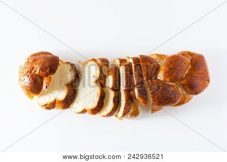 Cut Braided Bread Sprinkled With Poppy Seeds, Isolated On White.