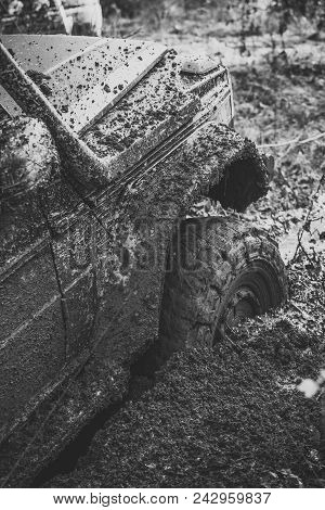 Fragment Of Car Stuck In Dirt, Close Up. Dangerous Expedition Concept. Offroad Tire Covered With Mud
