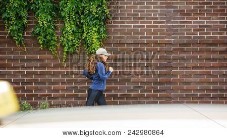 Young Woman Jogging Along The Street In Eurpean City In The Morning. Running Fitness Girl Against Br