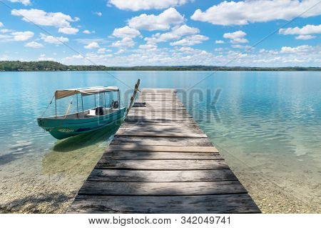 Boat At A Wooden Dock At Lake Itza With Turquoise Water, El Remate, Peten, Guatemala