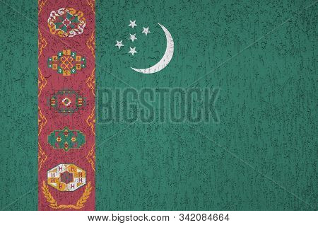 Turkmenistan Flag Depicted In Bright Paint Colors On Old Relief Plastering Wall. Textured Banner On 