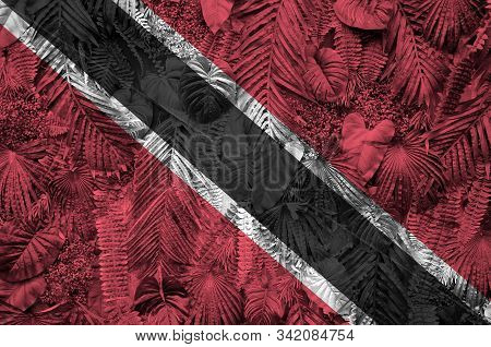 Trinidad And Tobago Flag Depicted On Many Leafs Of Monstera Palm Trees. Trendy Fashionable Backdrop