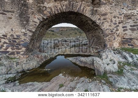 Ancient Roman Bridge Over The Salor River, Located Near Aliseda. Extremadura. Spain.