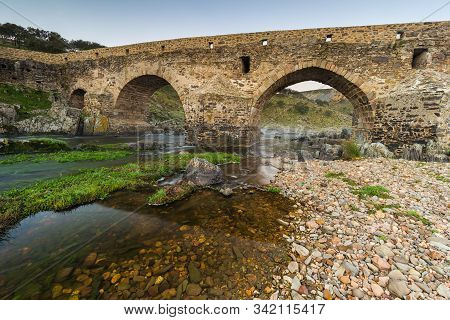 Ancient Roman Bridge Over The Salor River, Located Near Aliseda. Extremadura. Spain.