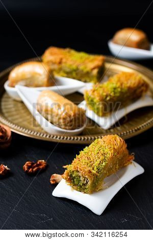 Food Concept Oriental Arab Dessert Baklava Walnuts And Rolled Kanafeh On Black Slate Board With Copy