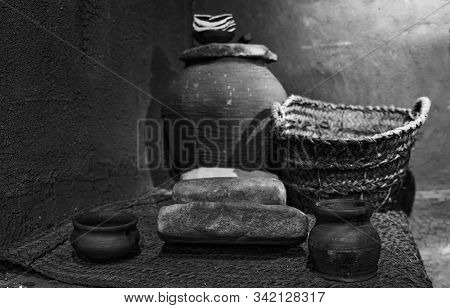 Set Of Ancient Pots And Containers In Mud And Reeds.