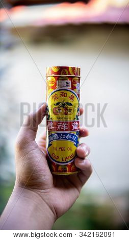Seremban, Malaysia - December 29, 2019: Hand Holding A Yu Yee Oil Cap Limau Metal Bottle Case. It Is