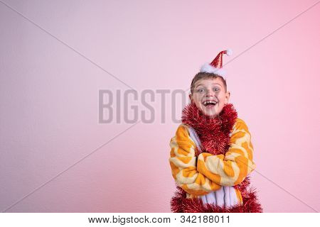 Excited Happy Laughing Child, Boy In Red Santa Hat Dressed In Giraffe Pajamas And Wrapped In Red New