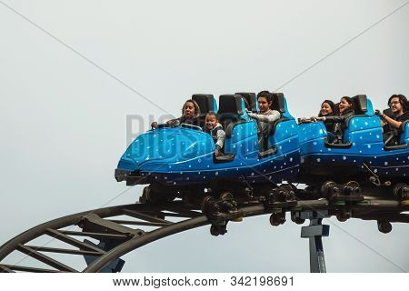 Canela, Brazil - July 21, 2019. People In A Blue Cart Having Fun On Roller Coaster In A Cloudy Day A