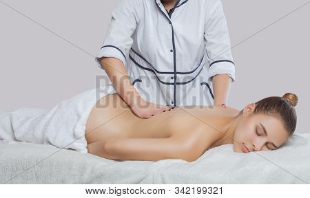 Masseur Makes A Relaxing Massage On The Neck, Shoulders, Back And Collarbones Of A Young Beautiful W