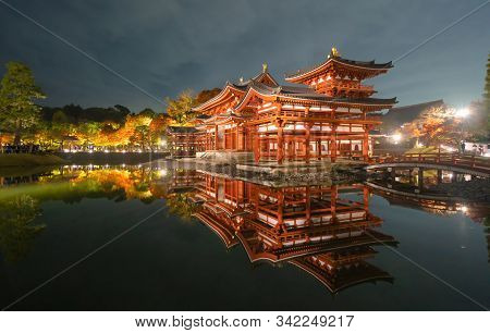 Byodoin Temple Pagoda And Lake With Red Maple Leaves Or Fall Foliage In Autumn Season. Colorful Tree