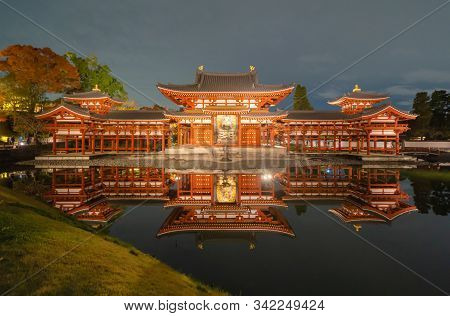 Byodoin Temple Pagoda And Lake With Red Maple Leaves Or Fall Foliage In Autumn Season. Colorful Tree