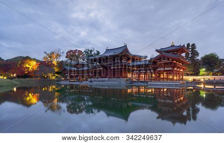 Byodoin Temple Pagoda And Lake With Red Maple Leaves Or Fall Foliage In Autumn Season. Colorful Tree